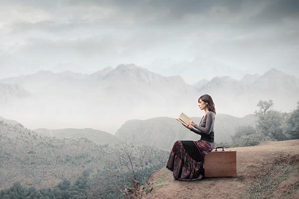 woman reading on cliff